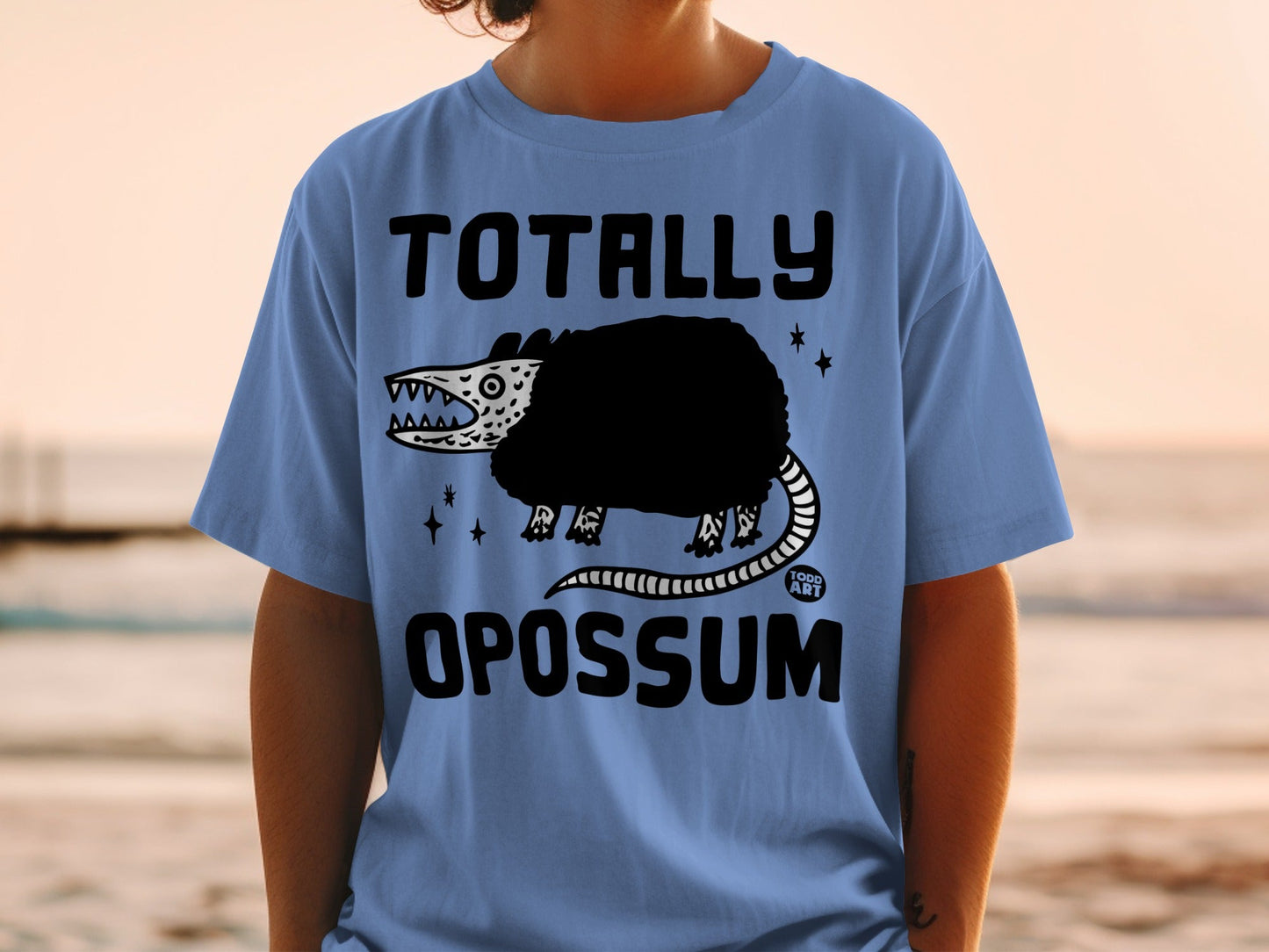 Light blue t-shirt with "TOTALLY OPOSSUM" text and a cartoon opossum.