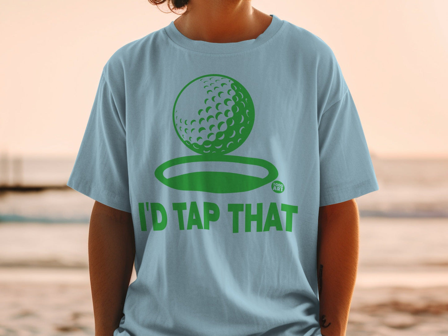 Light blue t-shirt with a green golf ball graphic and text "I'D TAP THAT".