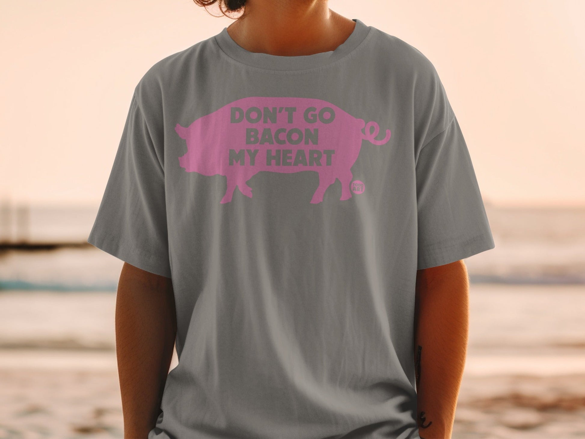 Grey t-shirt with pink pig graphic and text "Don't Go Bacon My Heart".