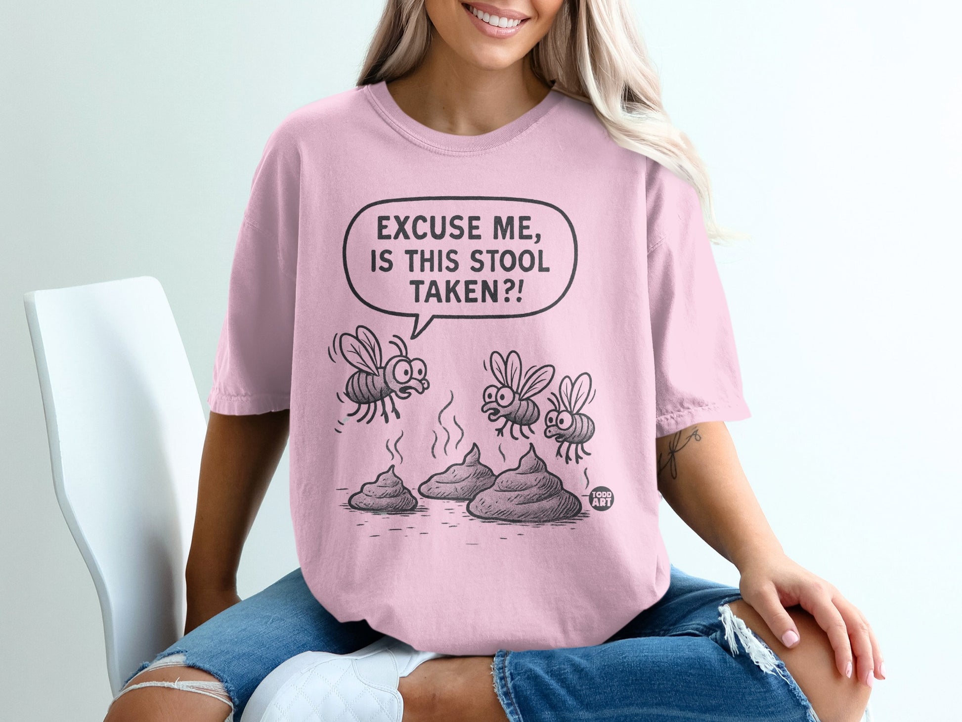 Pink t-shirt with cartoon flies and "Excuse me, is this stool taken?!" text.