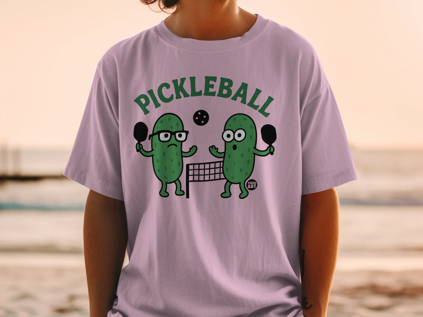 Two cartoon pickles play pickleball with paddles and a net.