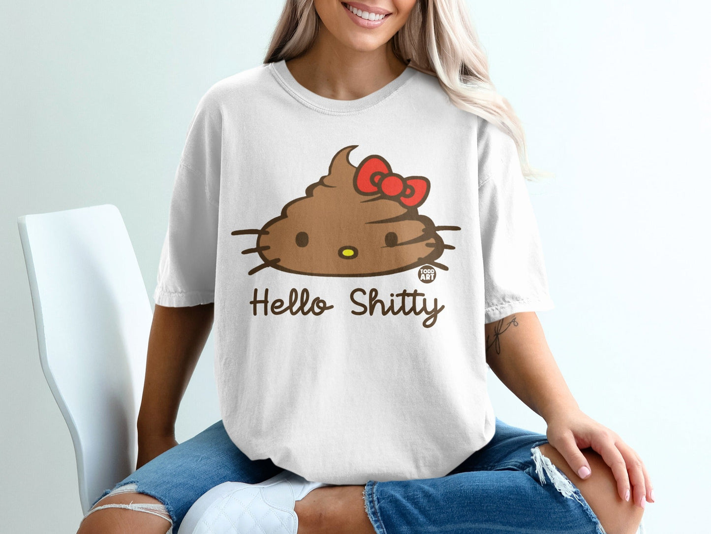 White t-shirt with brown Hello Shitty poop graphic and red bow.