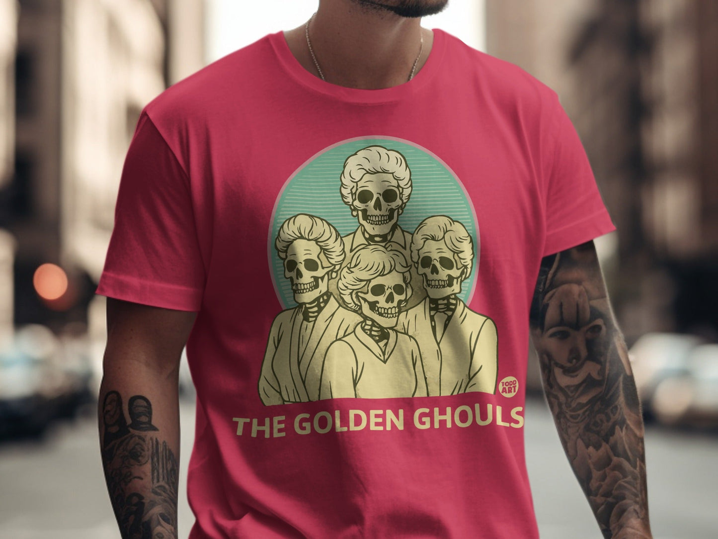 Crimson t-shirt with "THE GOLDEN GHOULS" and skeleton portraits.