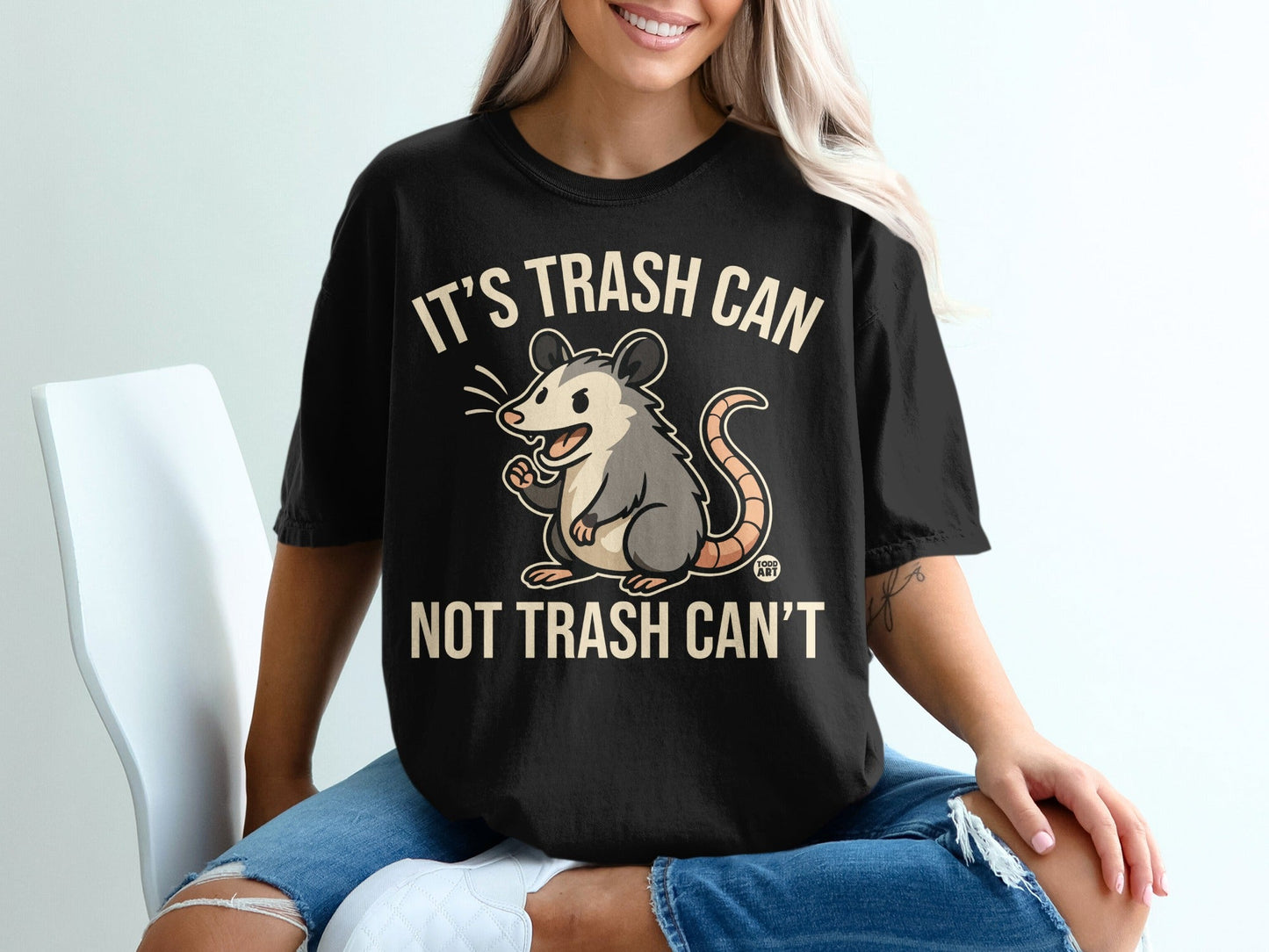 Black t-shirt with "It's Trash Can Not Trash Can't" and a cartoon opossum.