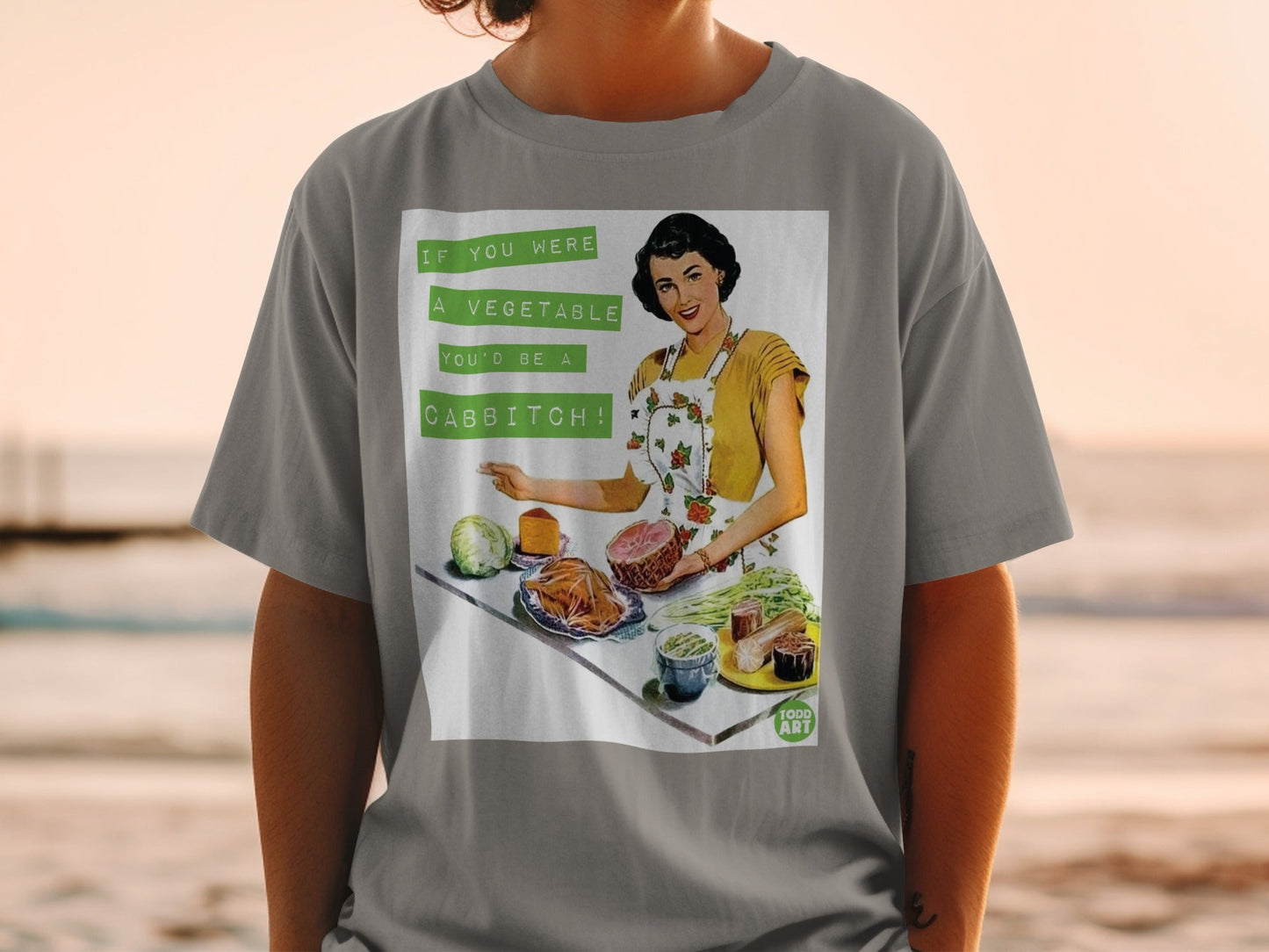 Woman in apron holding ham, with vegetables and text "If you were a vegetable you'd be a cabbitch!".