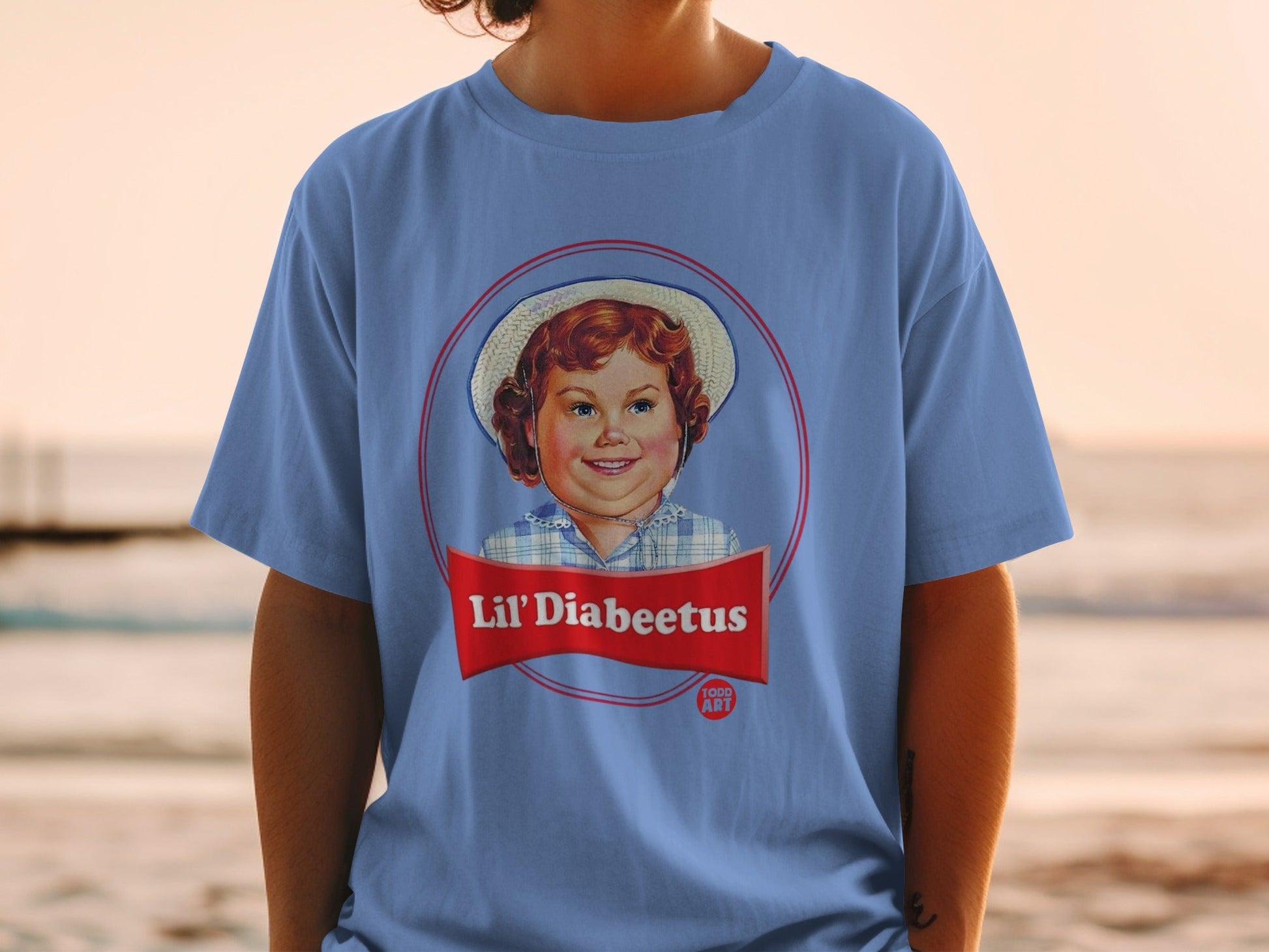 Blue t-shirt with a retro circular logo featuring a smiling child and "Lil' Diabeetus" text.