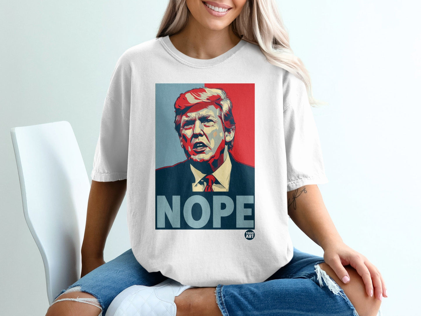 White t-shirt featuring a stylized portrait of Donald Trump with the word "NOPE".