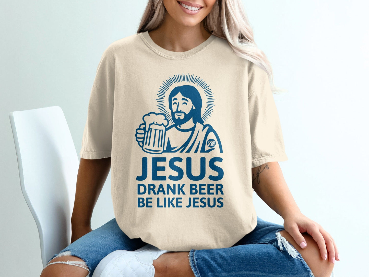 Cream t-shirt with "Jesus drank beer like Jesus" graphic and haloed Jesus holding beer mug.