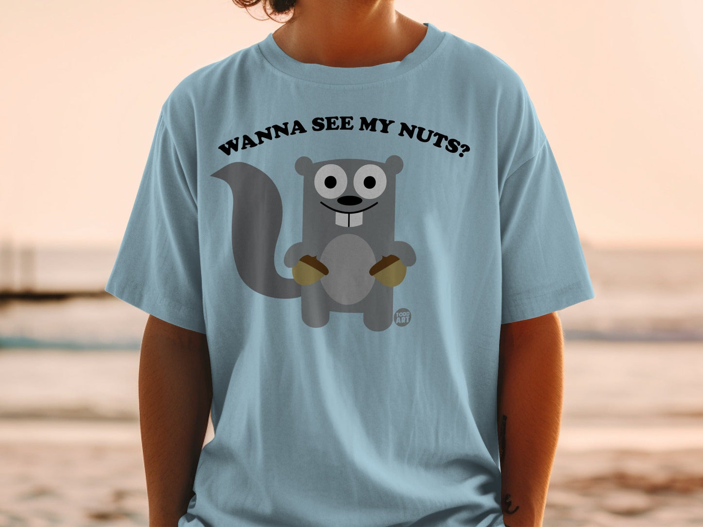 Light blue t-shirt with a cartoon squirrel saying "Wanna see my nuts?".