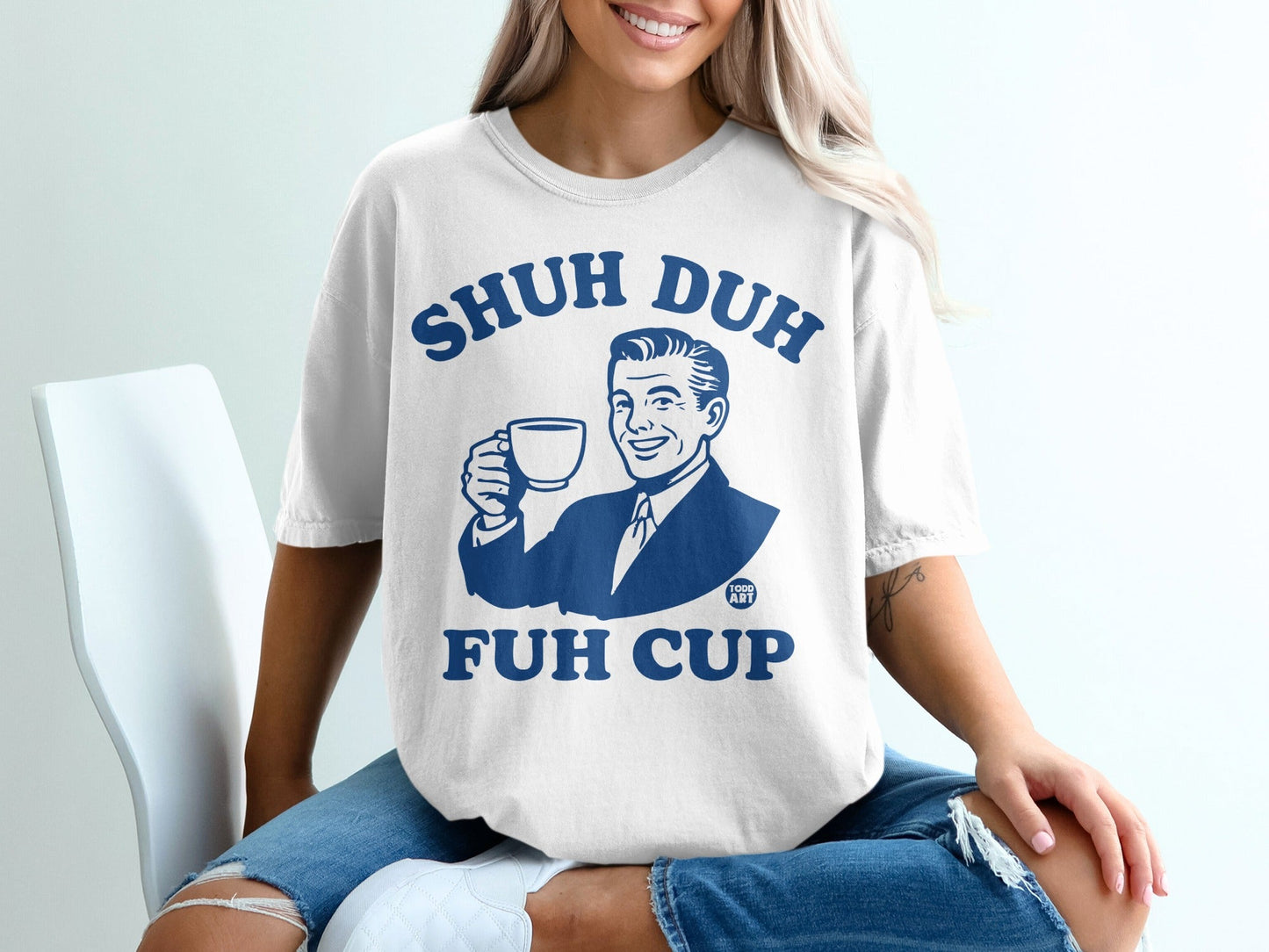 White t-shirt with "SHUH DUH FUH CUP" text and illustration of a man holding a coffee cup.