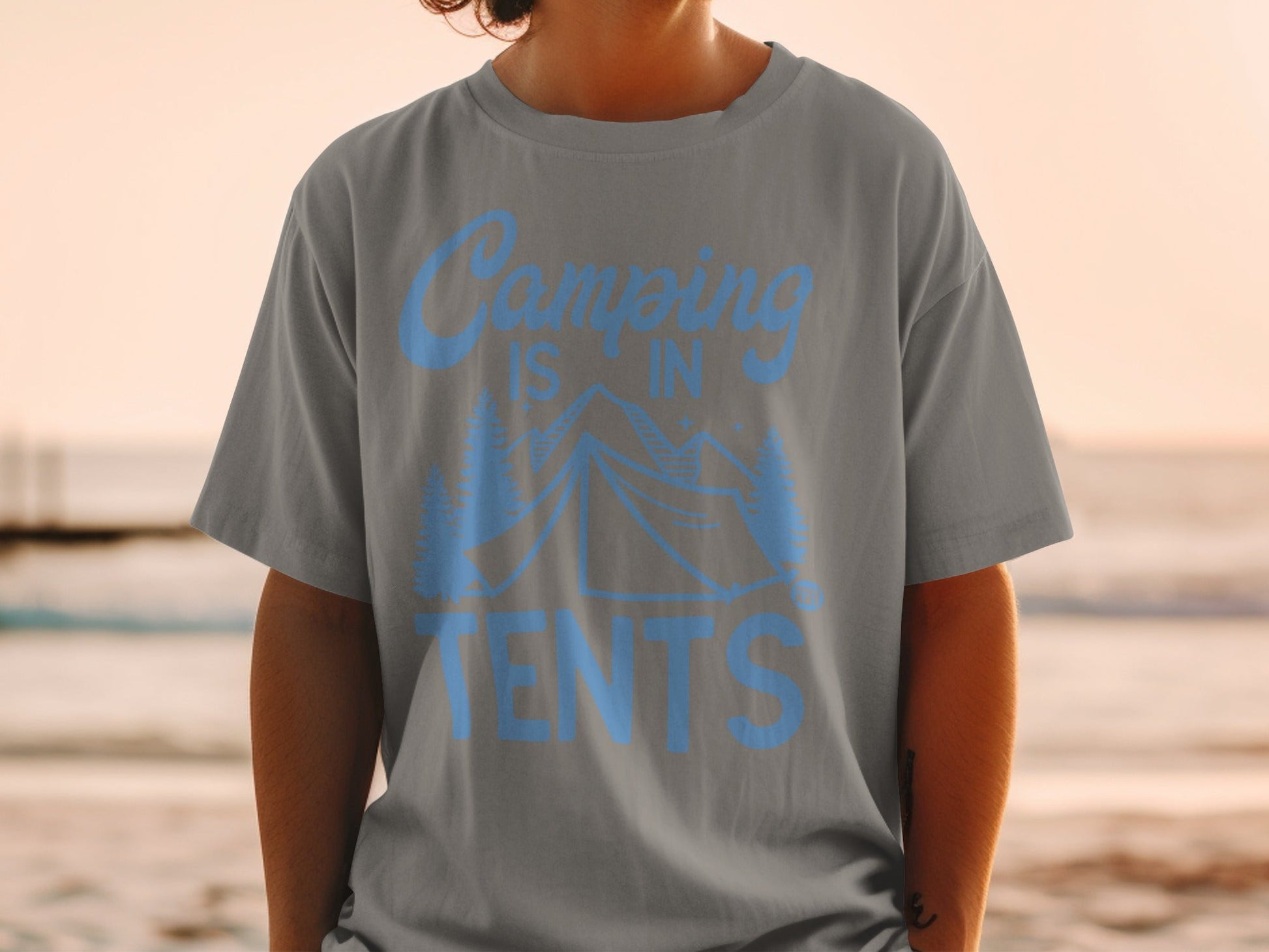 Gray t-shirt with blue text "Camping is in tents" and mountain graphic.
