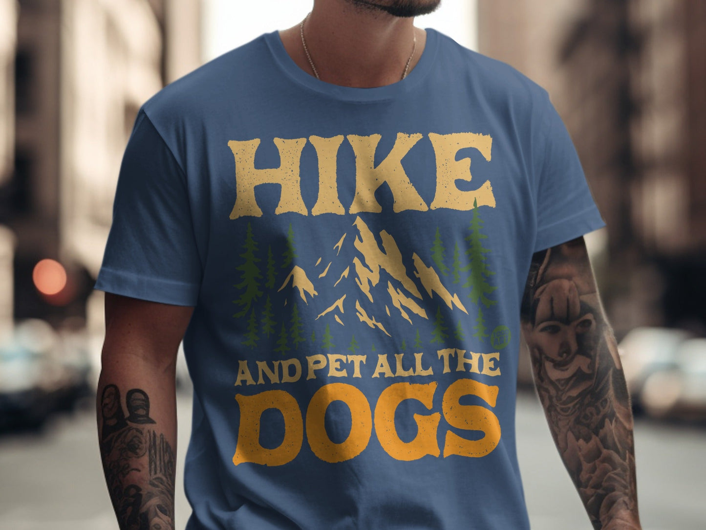 Blue t-shirt with "HIKE AND PET ALL THE DOGS" text and mountain graphic.