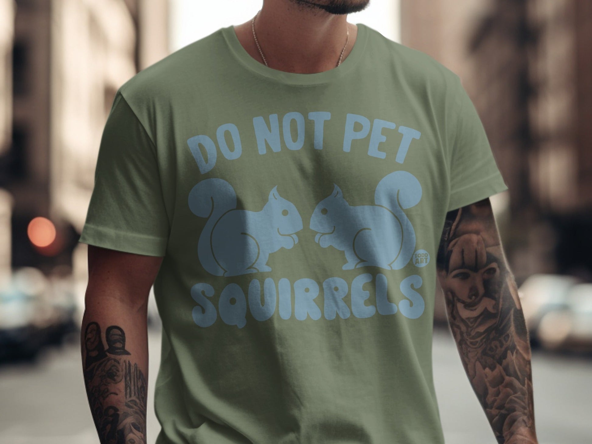 Olive green t-shirt with "DO NOT PET SQUIRRELS" and squirrel graphics.