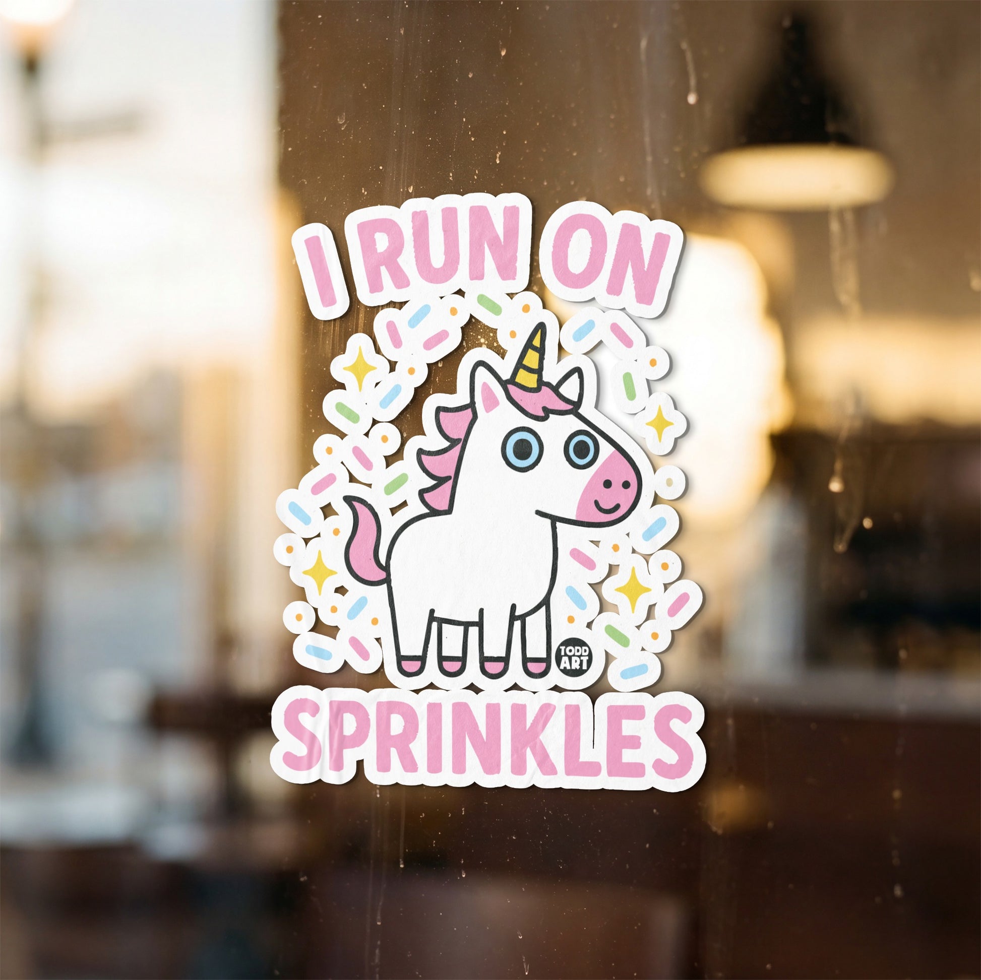 Sticker of a cartoon unicorn with pink mane and tail surrounded by colorful sprinkles.