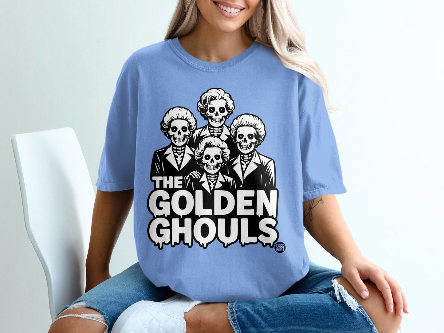 Blue t-shirt with "The Golden Ghouls" text and skeleton figures.