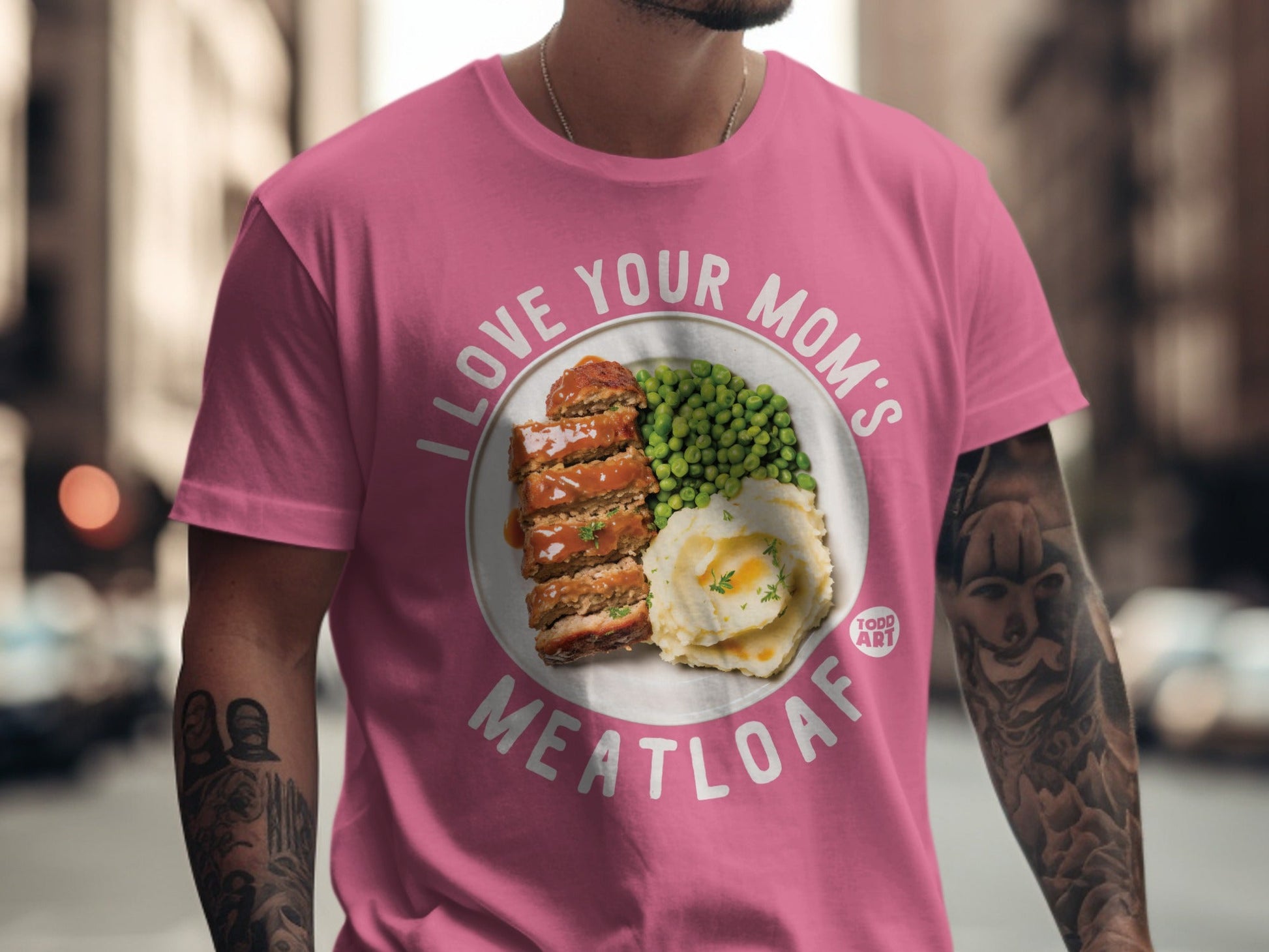 Pink t-shirt with "I love your mom's meatloaf" and a plate of meatloaf and peas.