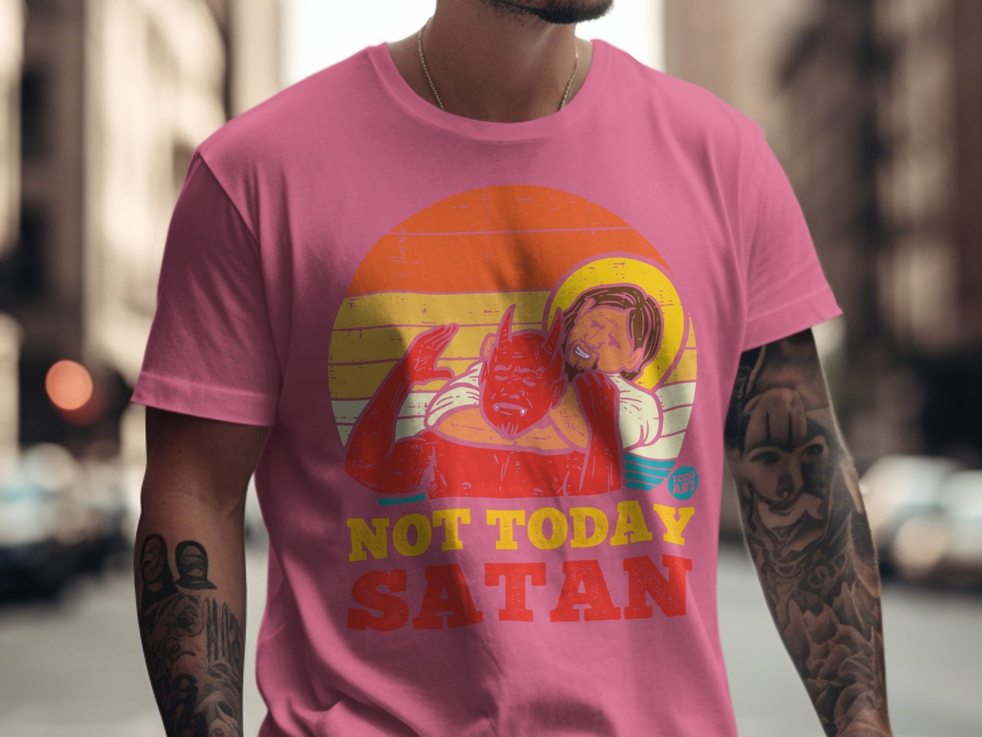 Pink t-shirt with "Not Today Satan" slogan and devil embracing a haloed figure.