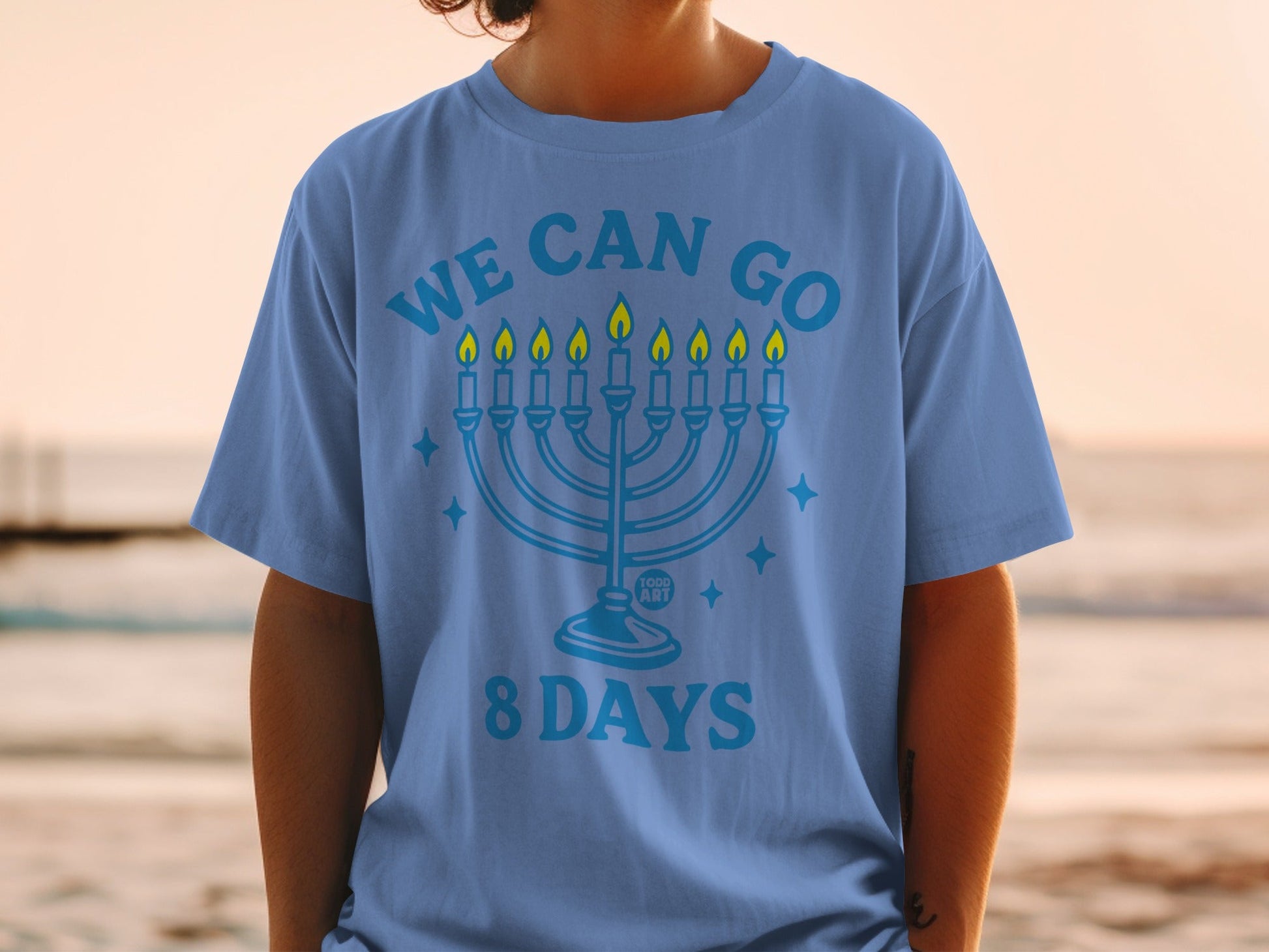 Blue t-shirt with a menorah and "WE CAN GO 8 DAYS" text.