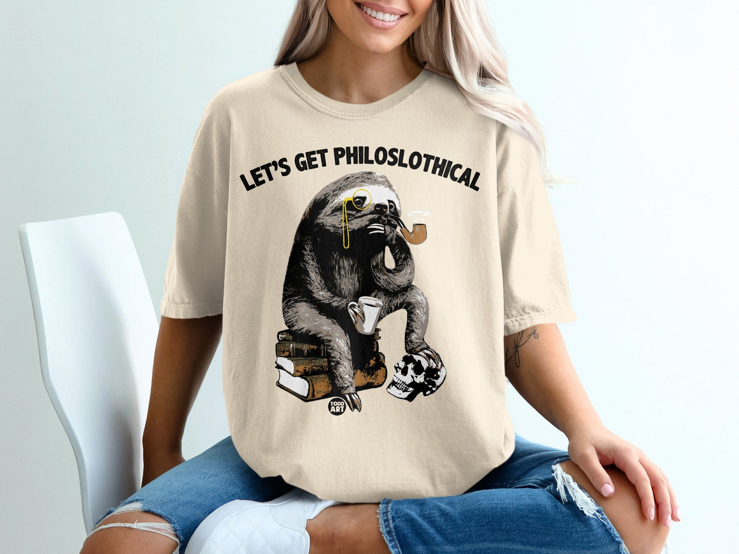 Sloth in monocle sits on books with pipe and skull, text "Let's Get Philosoph-lo-thical".