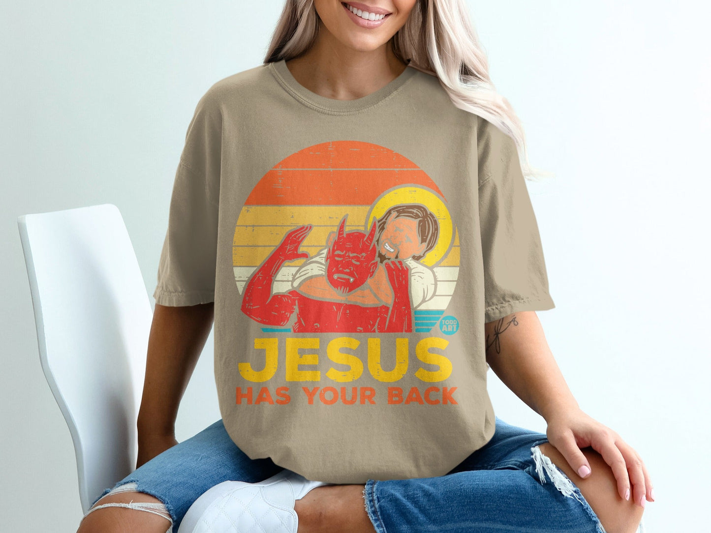 T-shirt with devil hugging Jesus, text "JESUS HAS YOUR BACK"