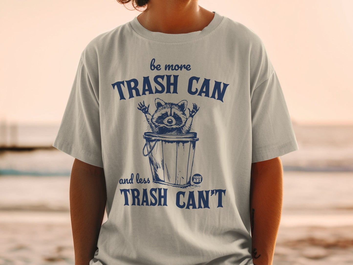 Trash panda in a bin with "be more trash can and less trash can't" text.