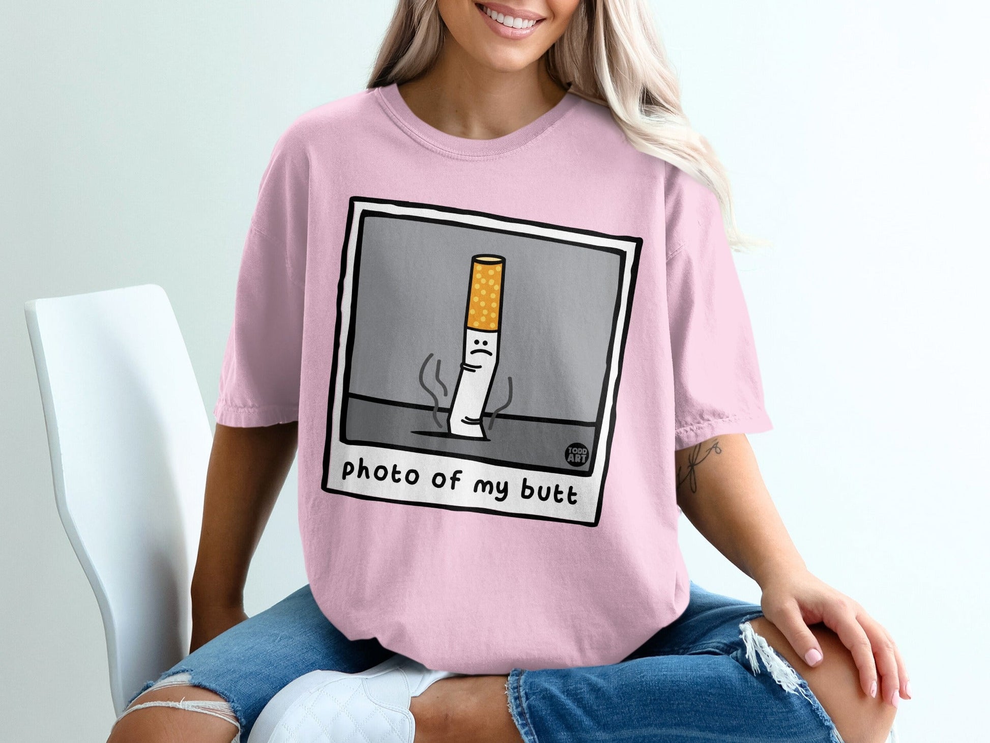 Pink t-shirt with cartoon cigarette graphic saying "photo of my butt".