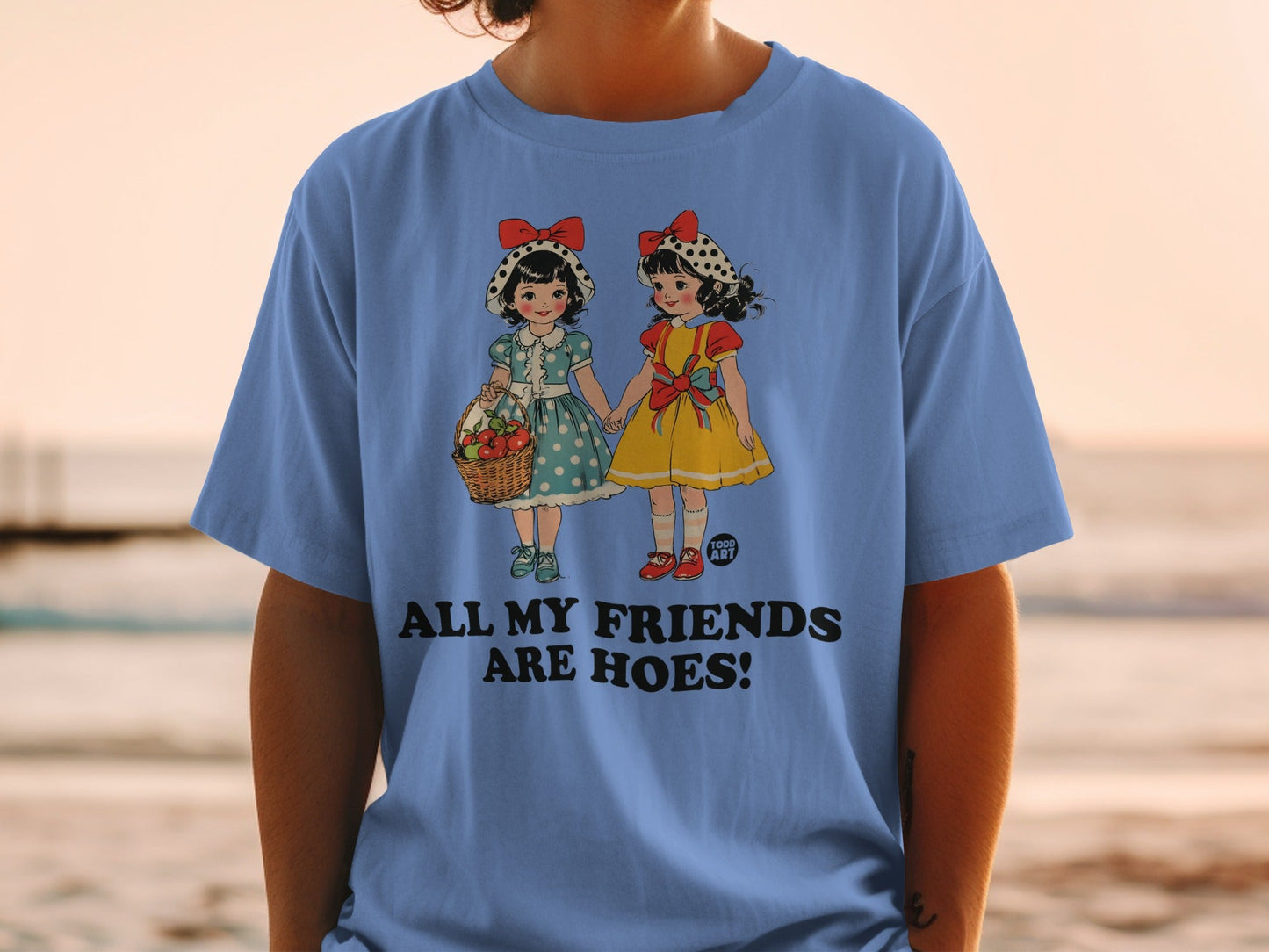 Two illustrated girls in dresses holding hands, text says "ALL MY FRIENDS ARE HOES."