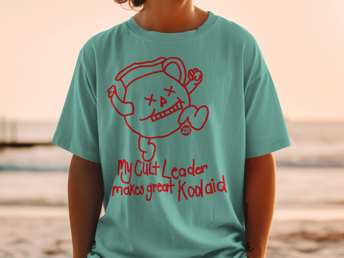 Teal t-shirt with red Kool-Aid Man graphic and "My Cult Leader" text.