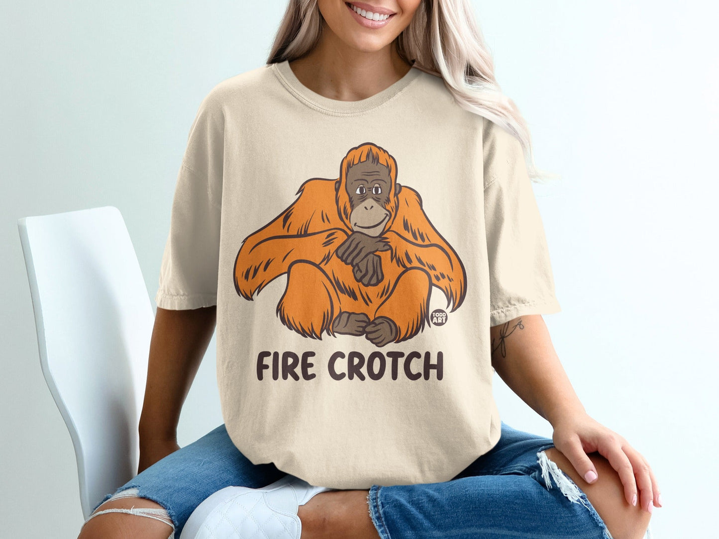 Beige t-shirt with an illustration of an orangutan and text reading "FIRE CROTCH".