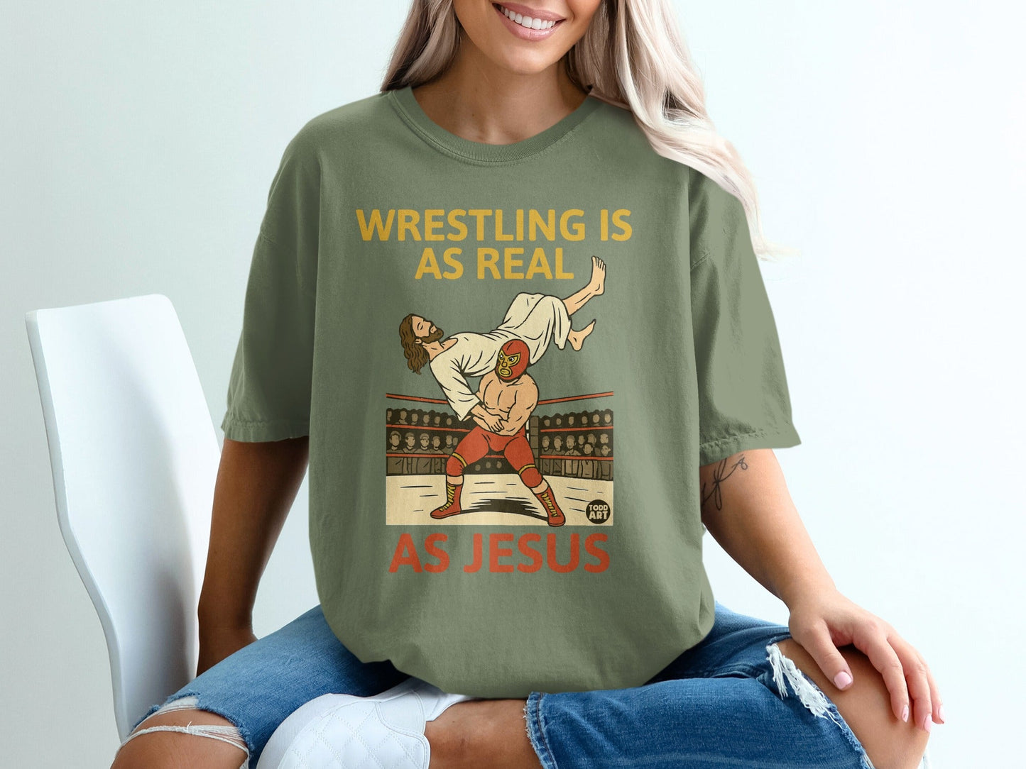 T-shirt with "Wrestling is Real As Jesus" graphic, showing a wrestler and Jesus.