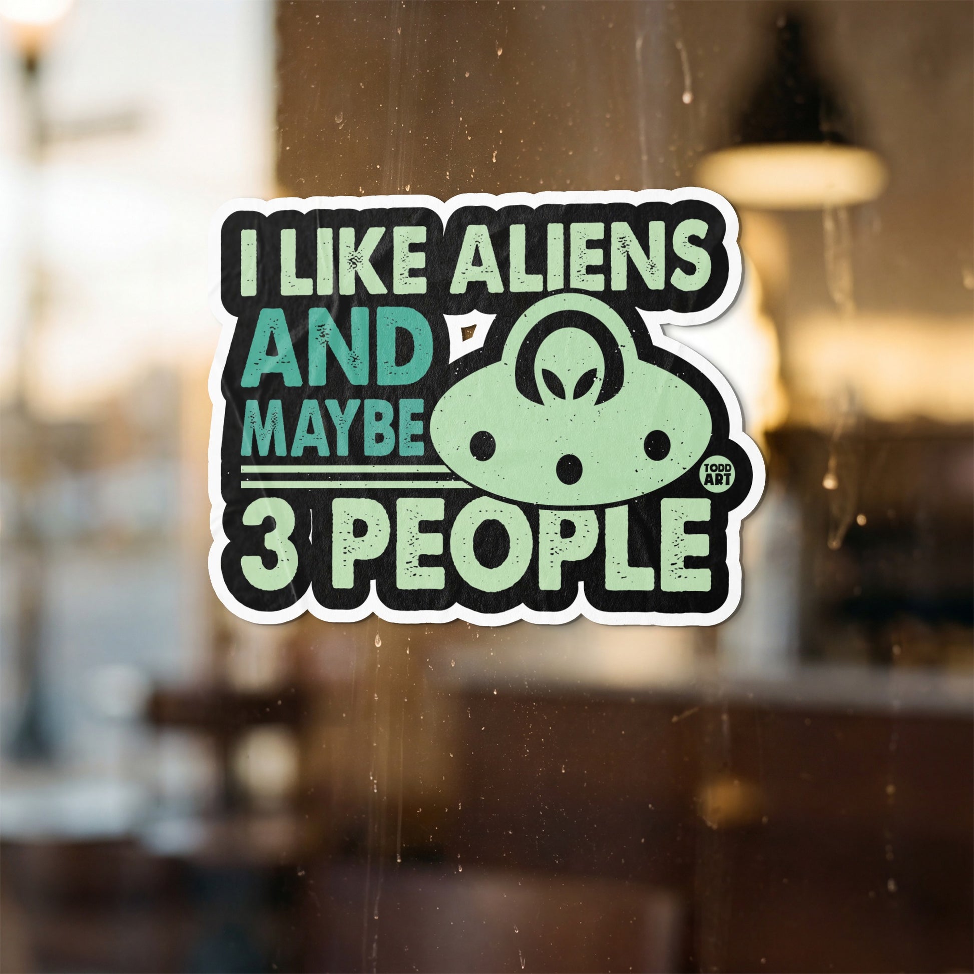 Sticker with text "I LIKE ALIENS AND MAYBE 3 PEOPLE" and a UFO.