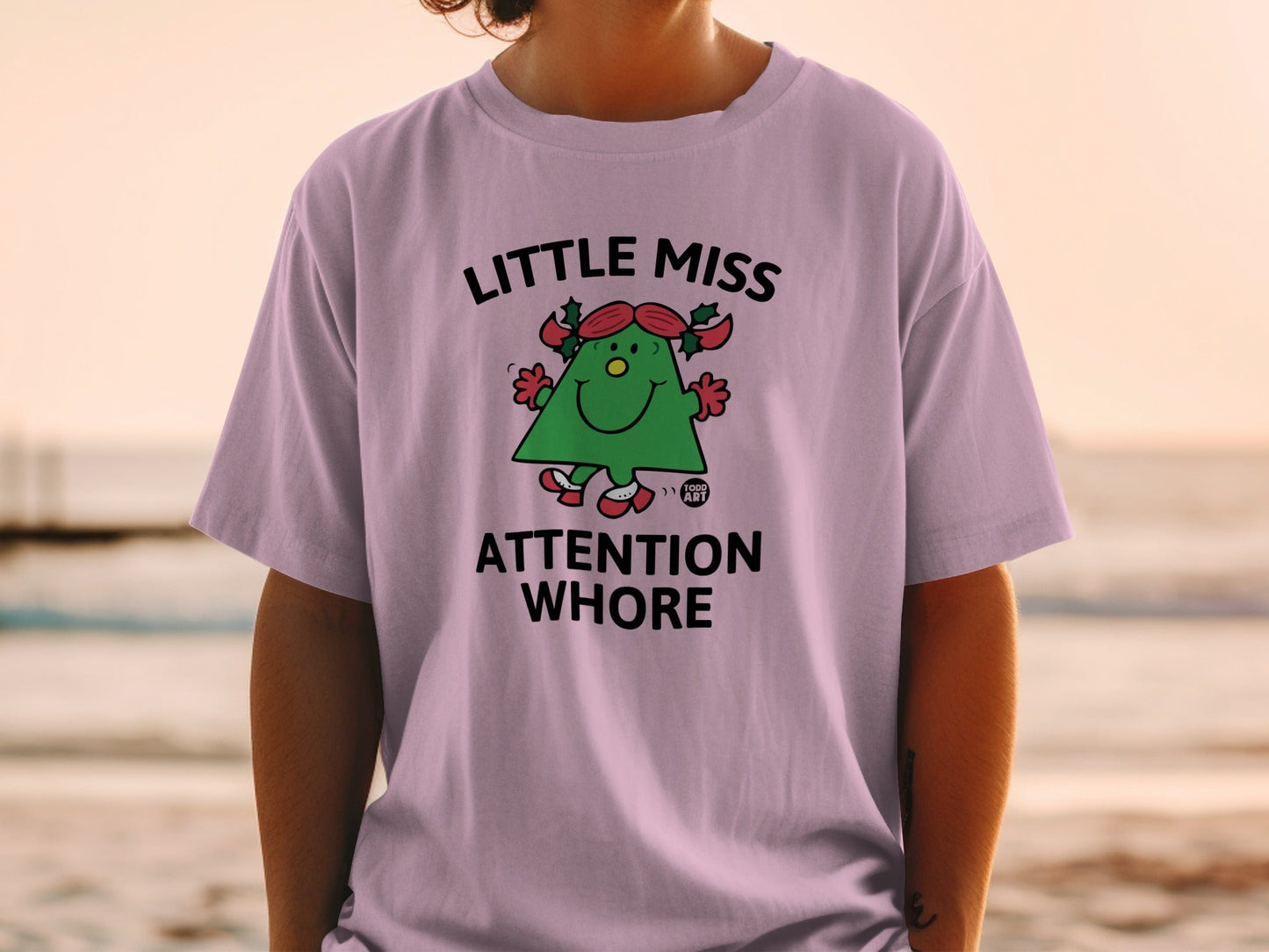 Purple t-shirt with a green cartoon character and "Little Miss Attention Whore" text.
