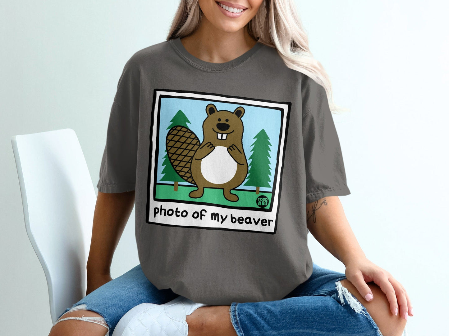Cartoon beaver smiling in front of trees with "photo of my beaver" text.
