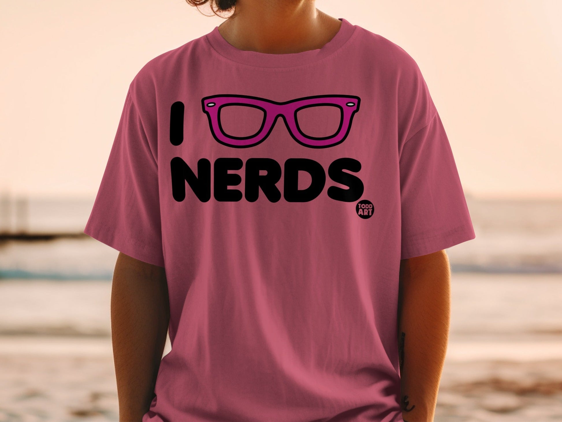 Pink t-shirt with "I [glasses icon] NERDS" and "TODD ART" logo.
