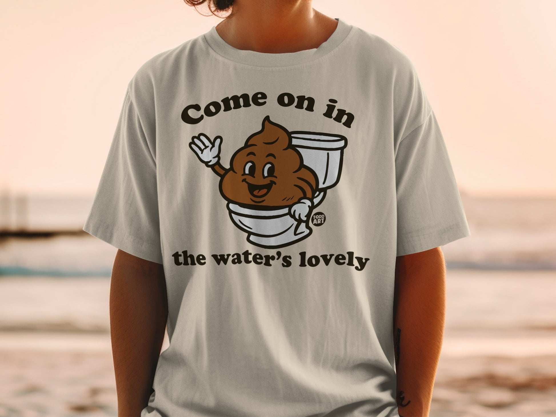 T-shirt with cartoon poop character in toilet, "Come on in the water's lovely" text.