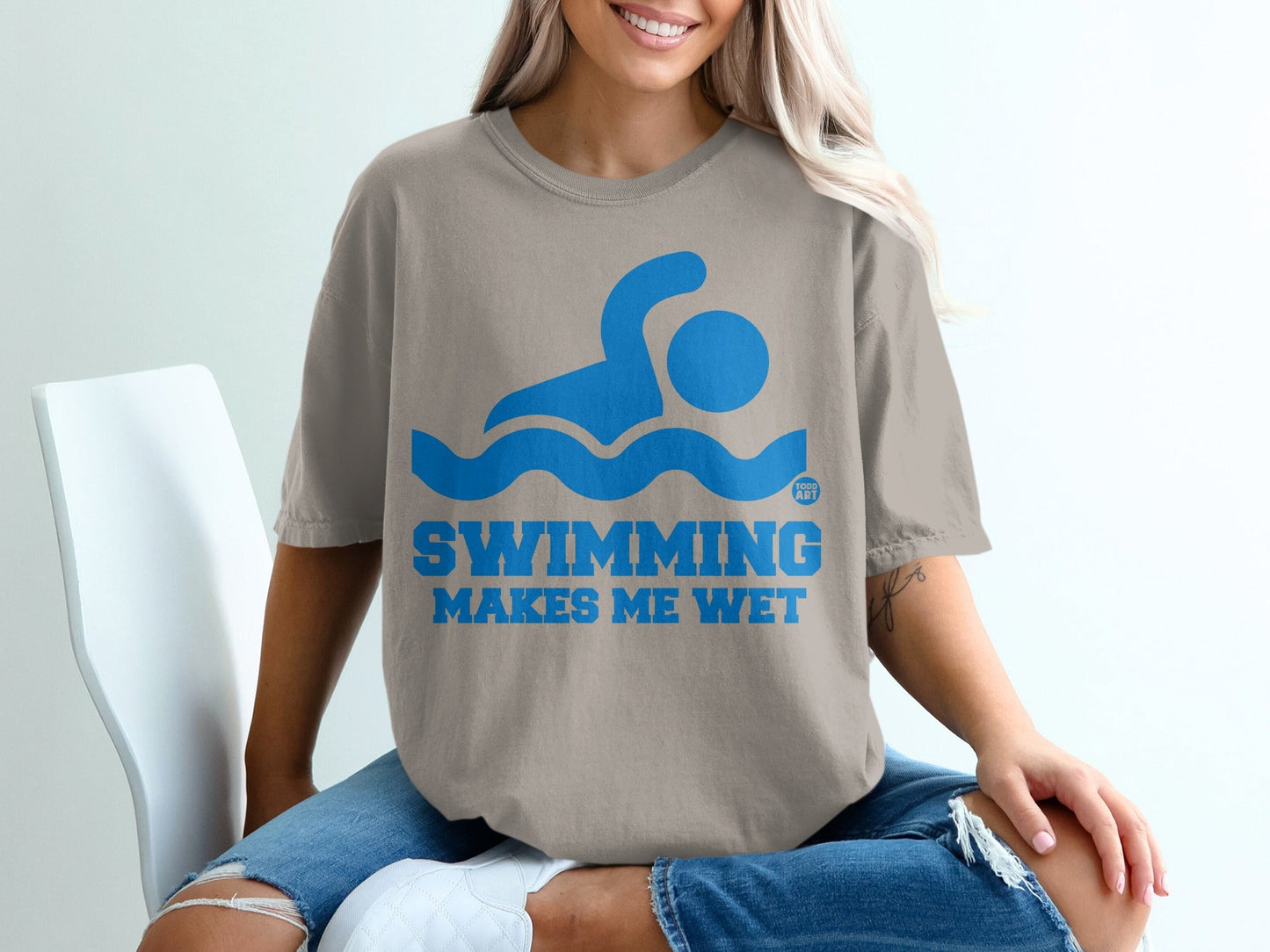Shirt with blue swimming graphic and text "SWIMMING MAKES ME WET".