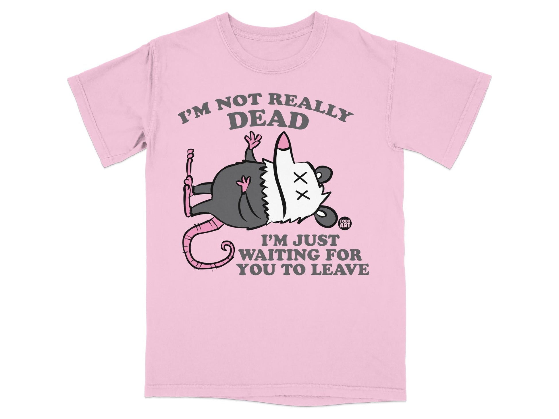 Pink t-shirt with a cartoon opossum and text: "I'm not really dead. I'm just waiting for you to leave."