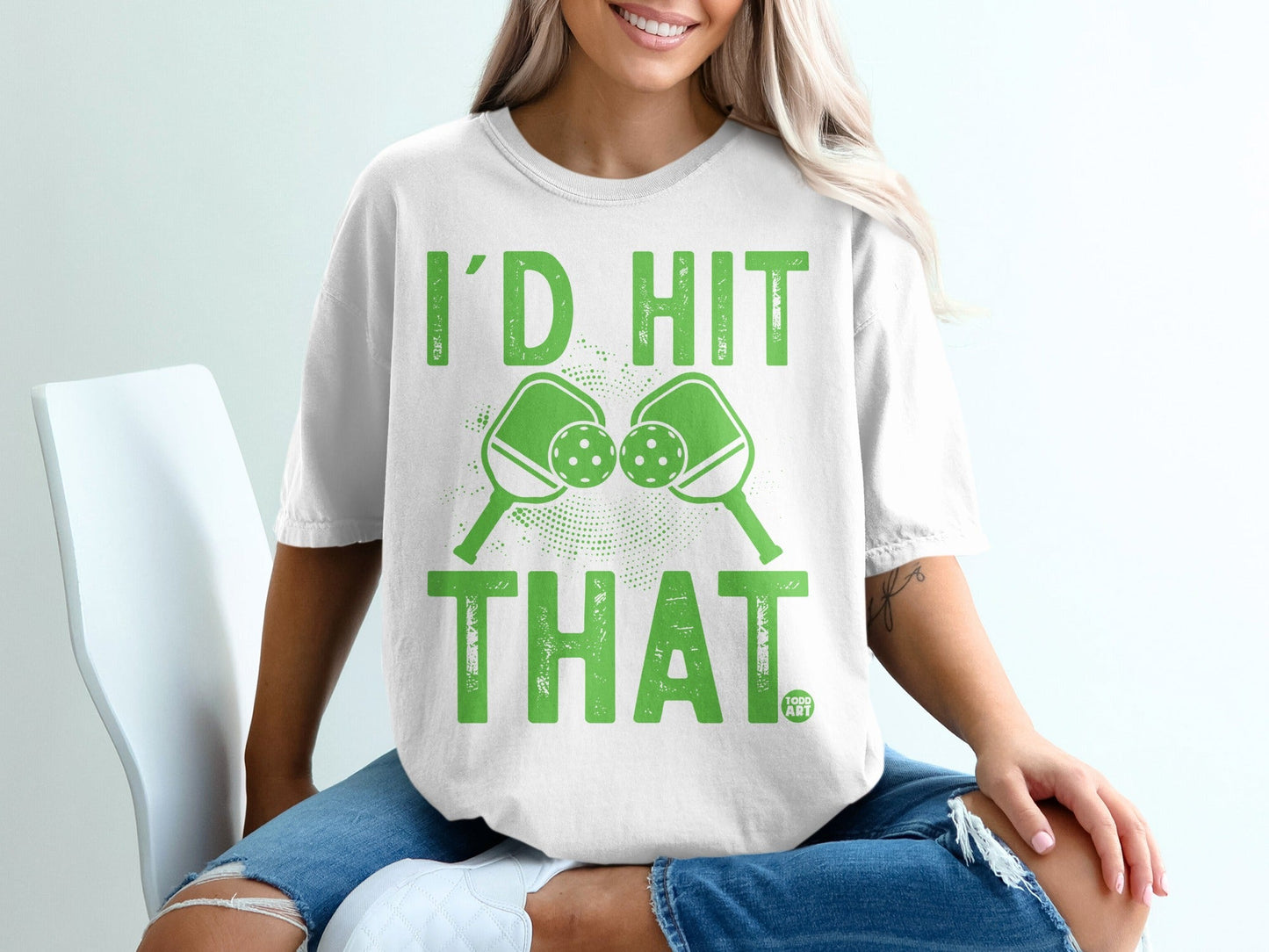 White t-shirt with "I'D HIT THAT" and crossed pickleball paddles design.