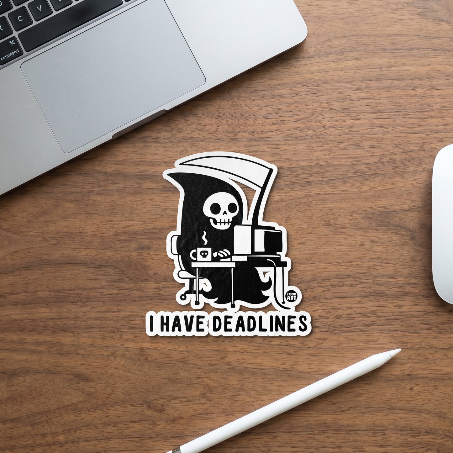 Grim Reaper sticker sits on desk with text "I HAVE DEADLINES"