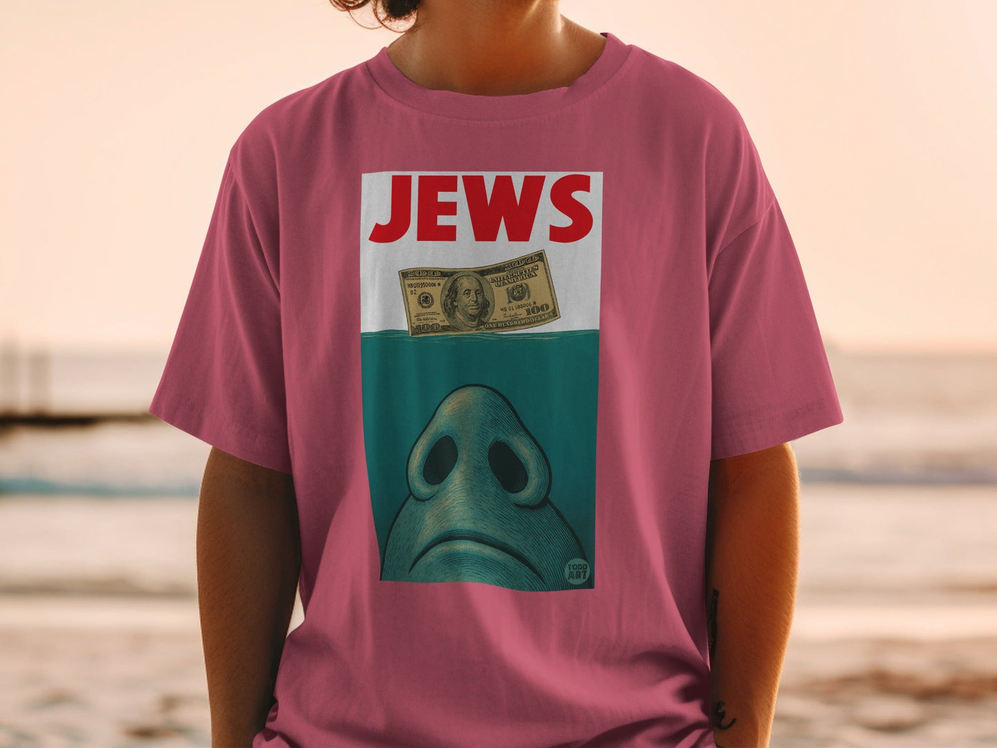 Pink t-shirt with "JEWS" and a shark fin over a dollar bill.