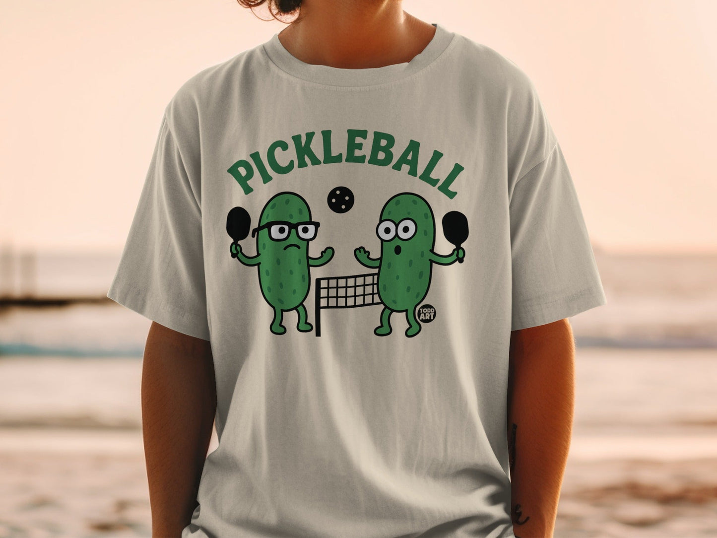 Two cartoon pickles playing pickleball on a court.