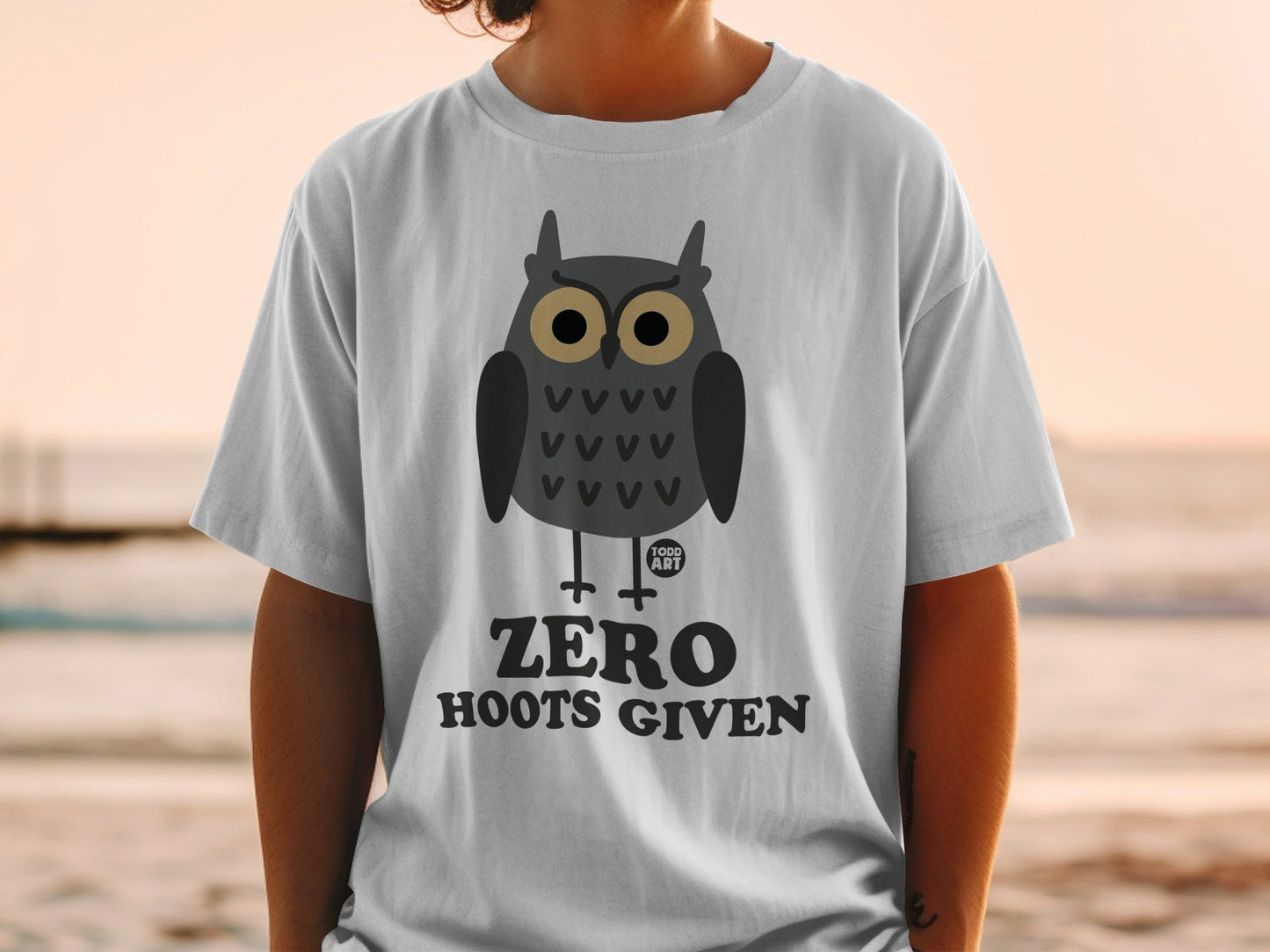 White t-shirt with cartoon owl graphic and text "ZERO HOOTS GIVEN".