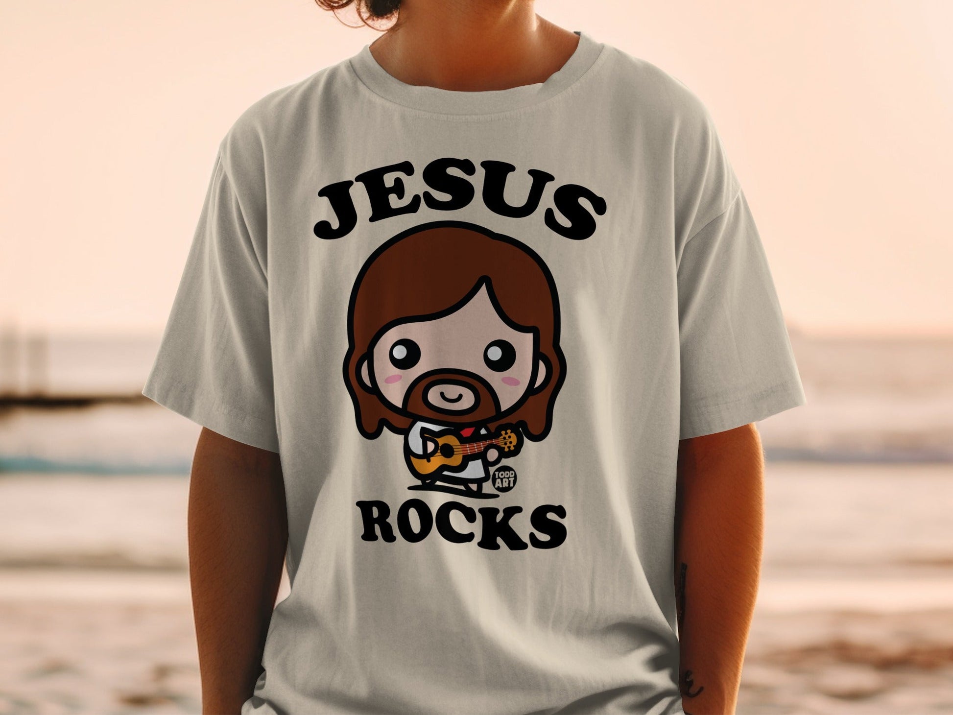 T-shirt with cartoon Jesus playing guitar, text "Jesus Rocks".