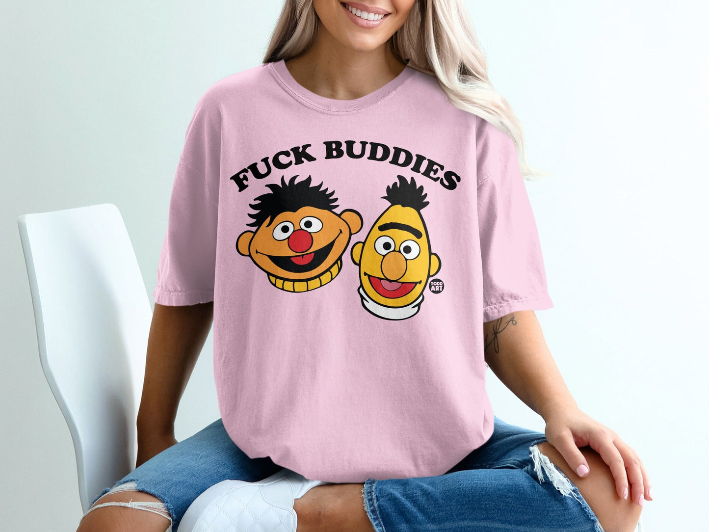 Pink t-shirt with cartoon faces of Ernie and Bert from Sesame Street.