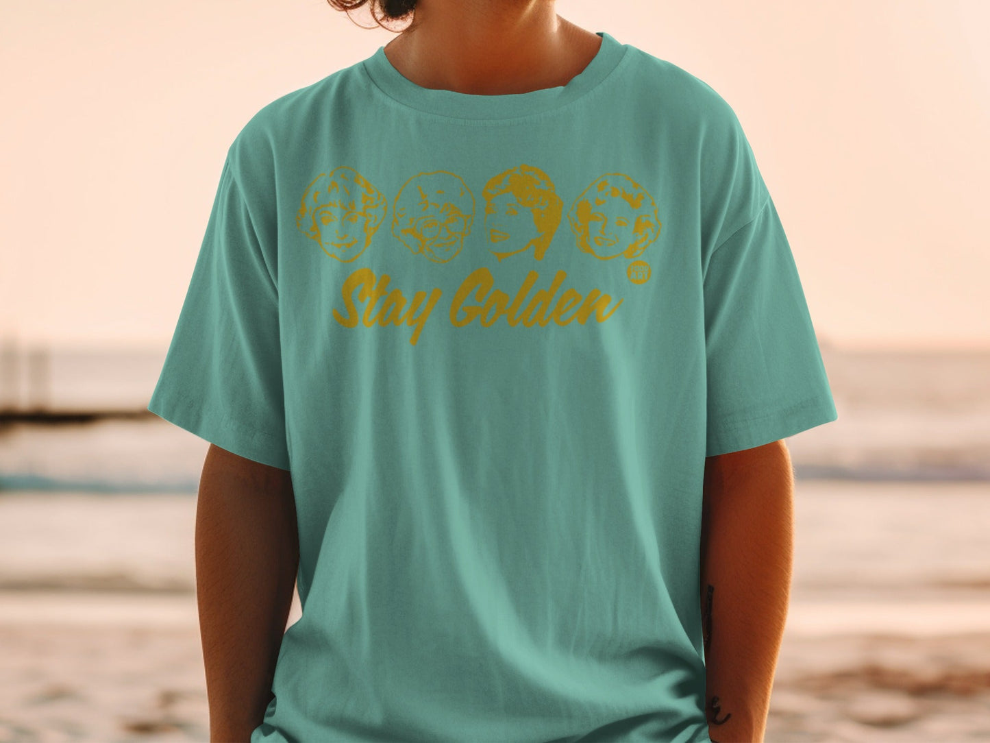 Teal t-shirt with "Stay Golden" text and The Golden Girls faces graphic.