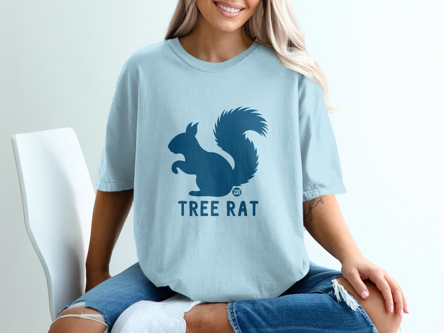 Light blue t-shirt with a dark blue squirrel graphic and "TREE RAT" text.