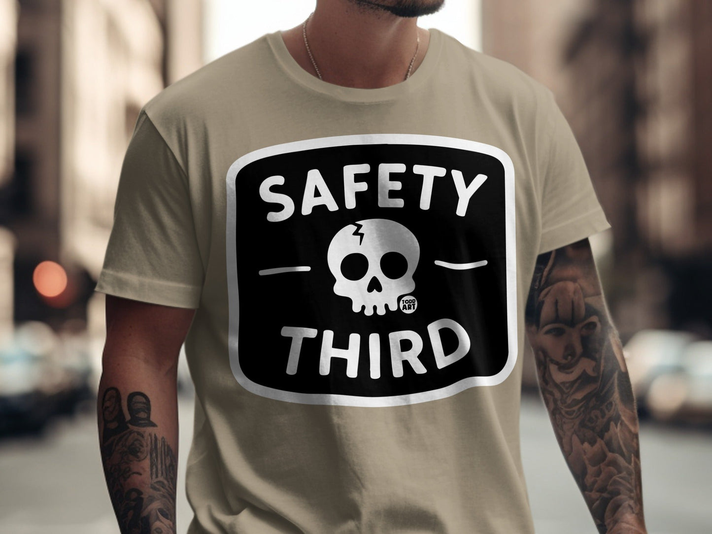 T-shirt with "SAFETY THIRD" and skull graphic on tan fabric.
