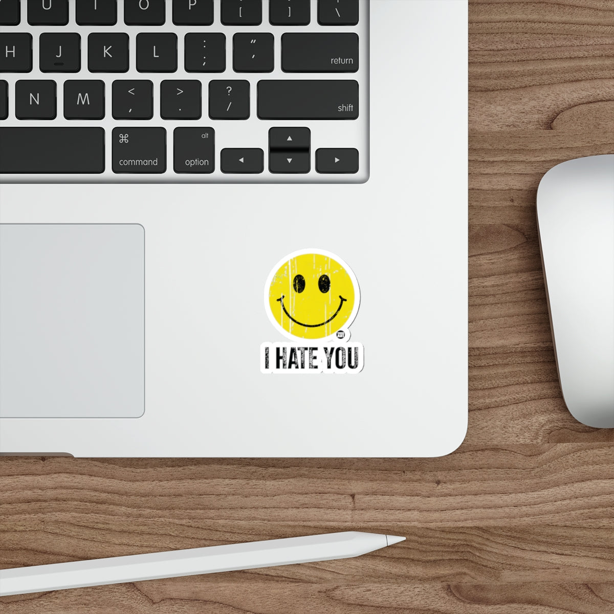 Sticker with yellow smiley face and "I HATE YOU" text on a laptop.