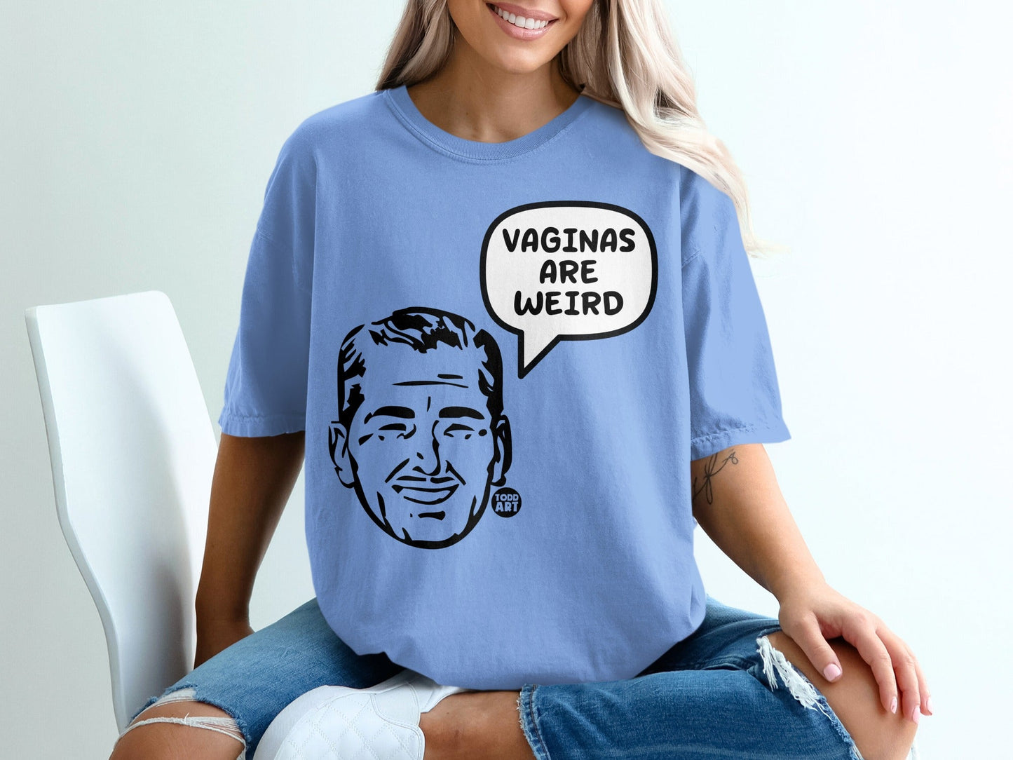 Blue t-shirt with a black graphic of a man speaking the words "VAGINAS ARE WEIRD".