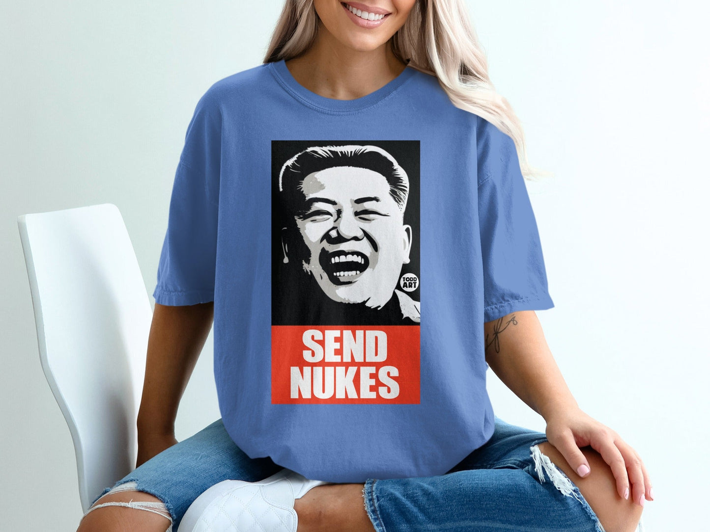 Blue t-shirt with graphic of Kim Jong Un laughing, "SEND NUKES" text.